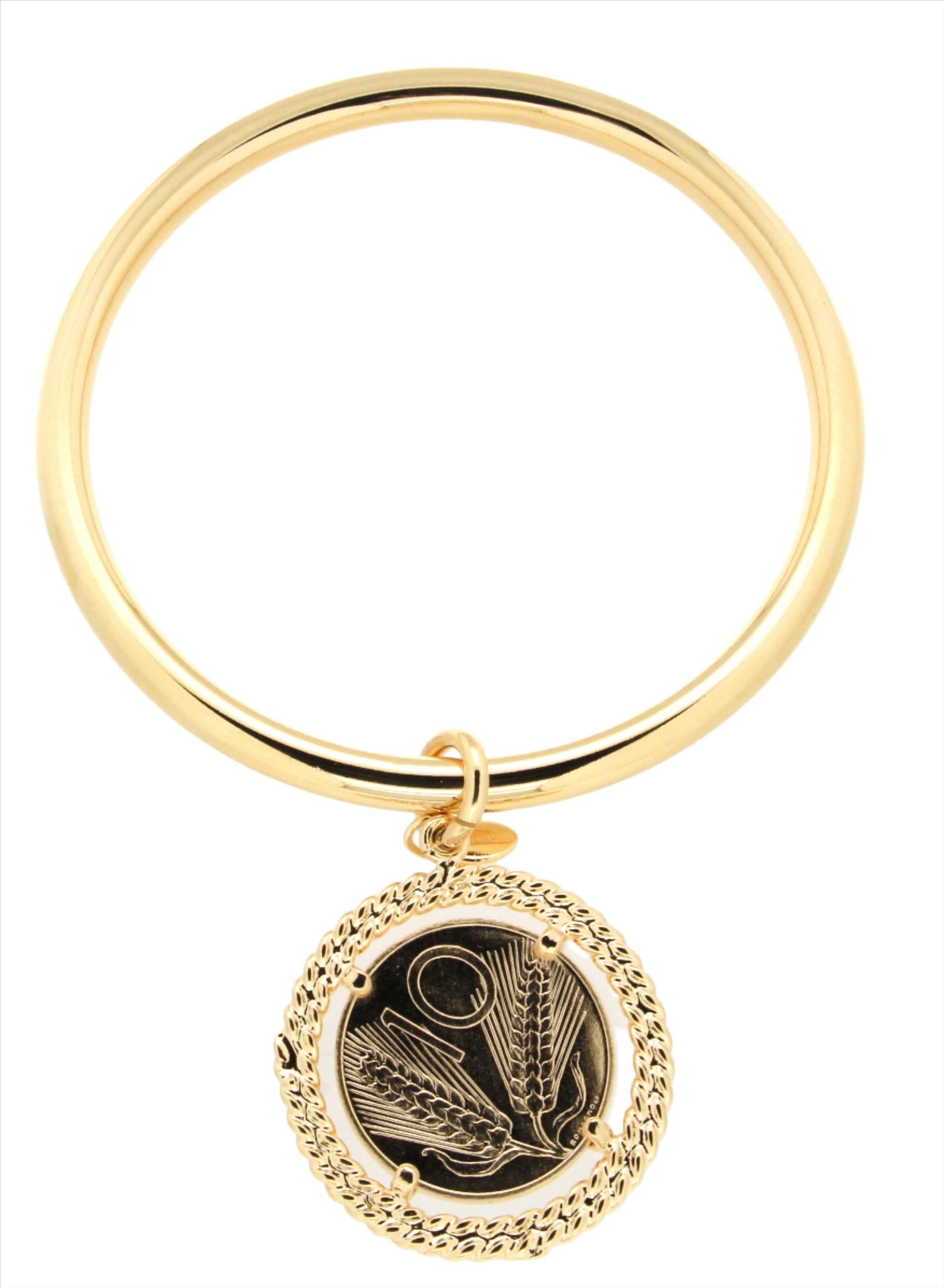 A gold bangle featuring a sleek, smooth band with a decorative pendant attached. The pendant showcases an intricate design of wheat stalks in a black finish, framed by a twisted gold rope detail.