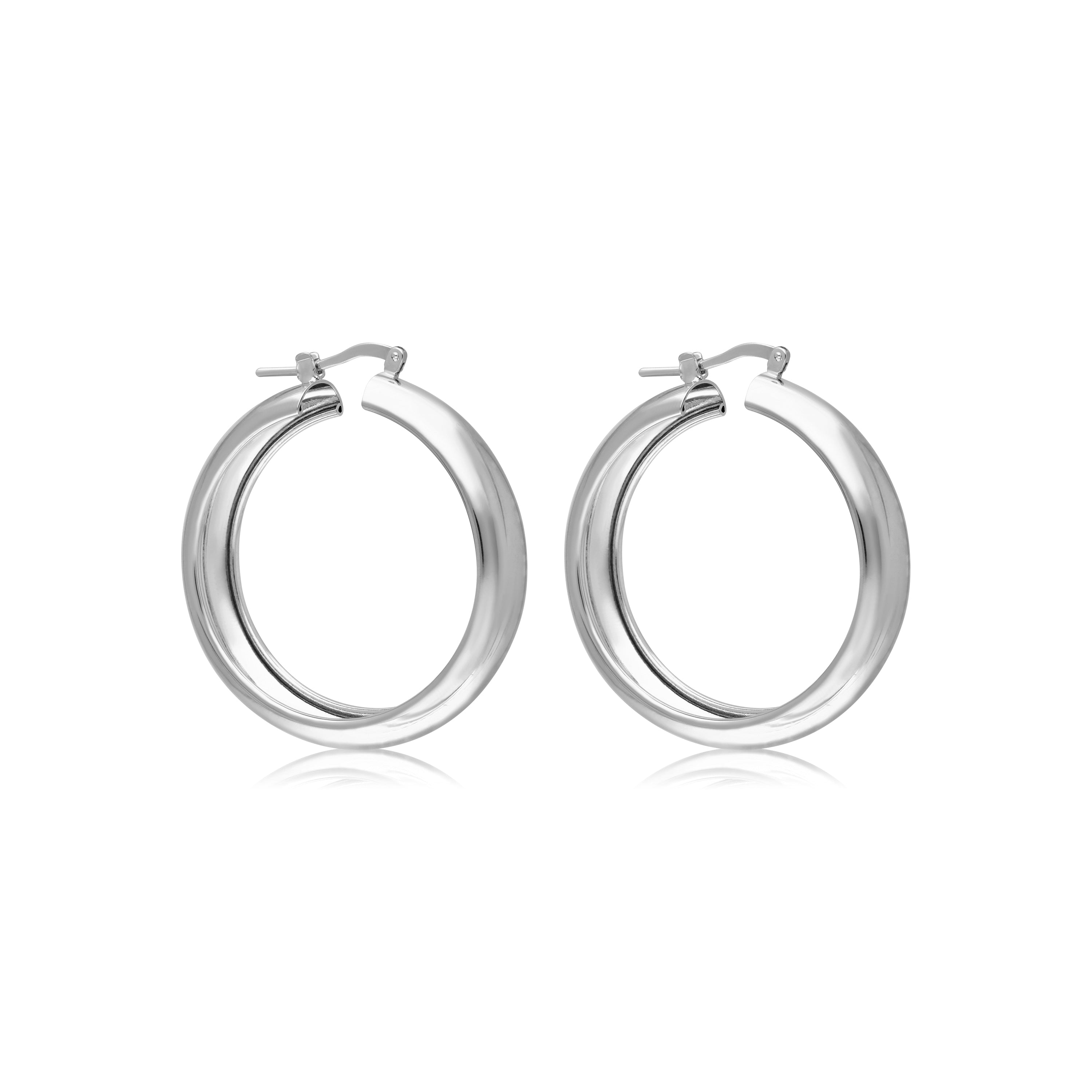 A pair of sleek silver-tone hoop earrings with a polished finish. The earrings feature a contemporary design with a slightly rounded shape that adds sophistication. Each hoop is secured with a clasp, providing a comfortable fit. The reflective surface creates a brilliant shine, making these earrings a versatile accessory suitable for both casual and formal occasions. They can enhance any outfit with a touch of elegance and modern flair.