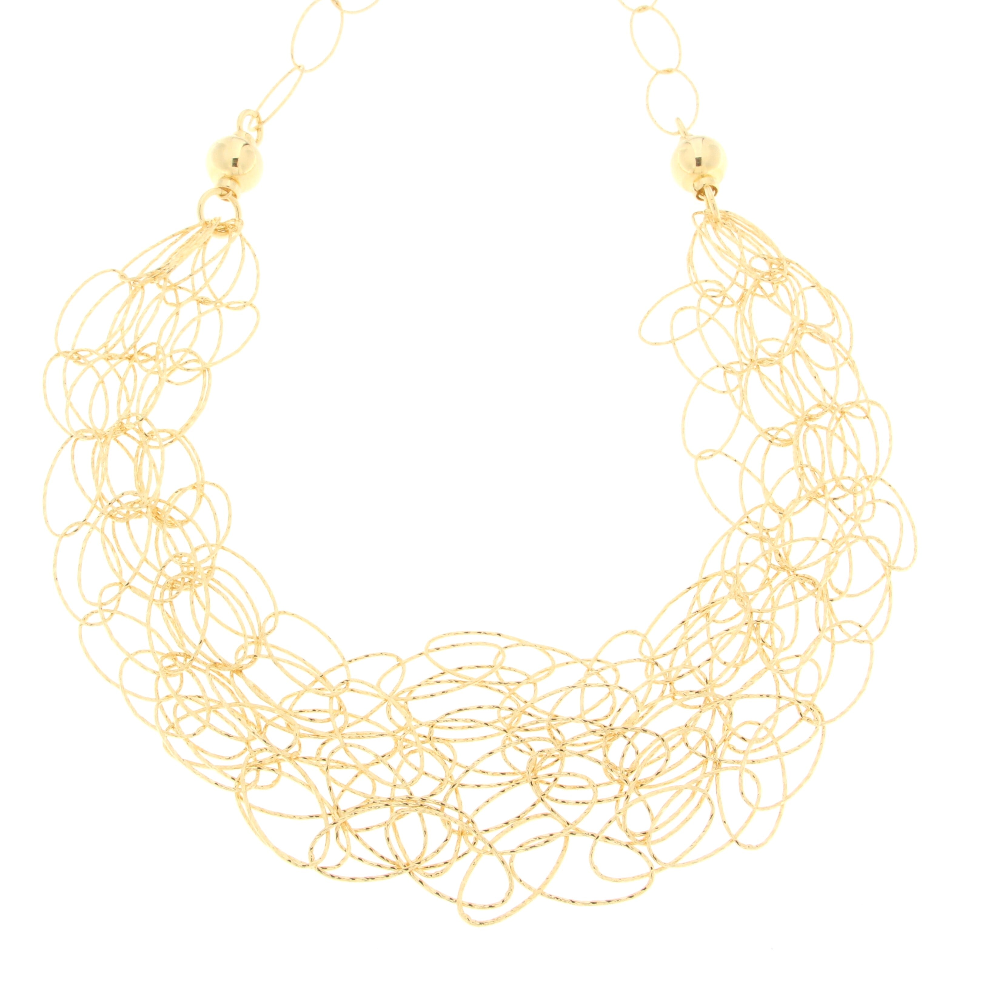 Artistic gold necklace with intertwined circular loops creating a lace-like effect, featuring round beads for added detail, showcasing a unique and elegant design.