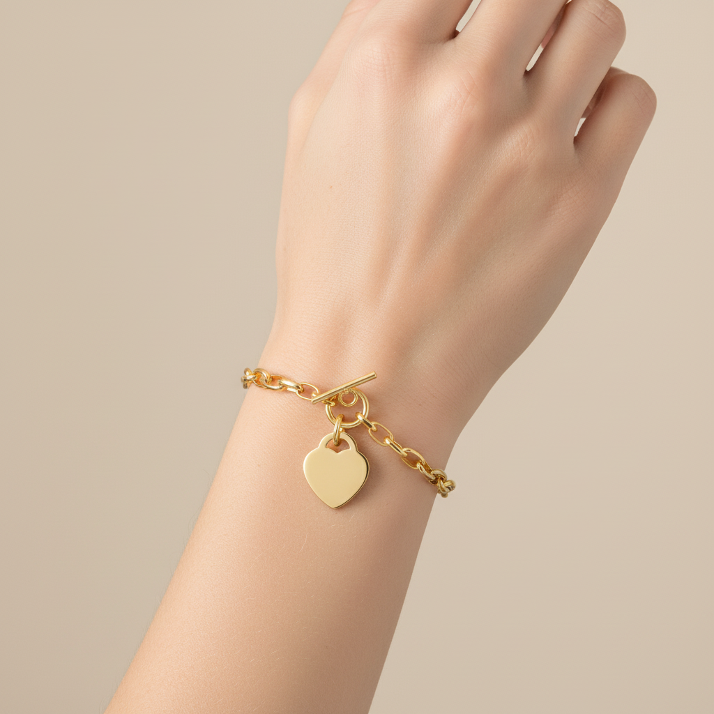 Gold chain bracelet with flat heart charm on model's wrist