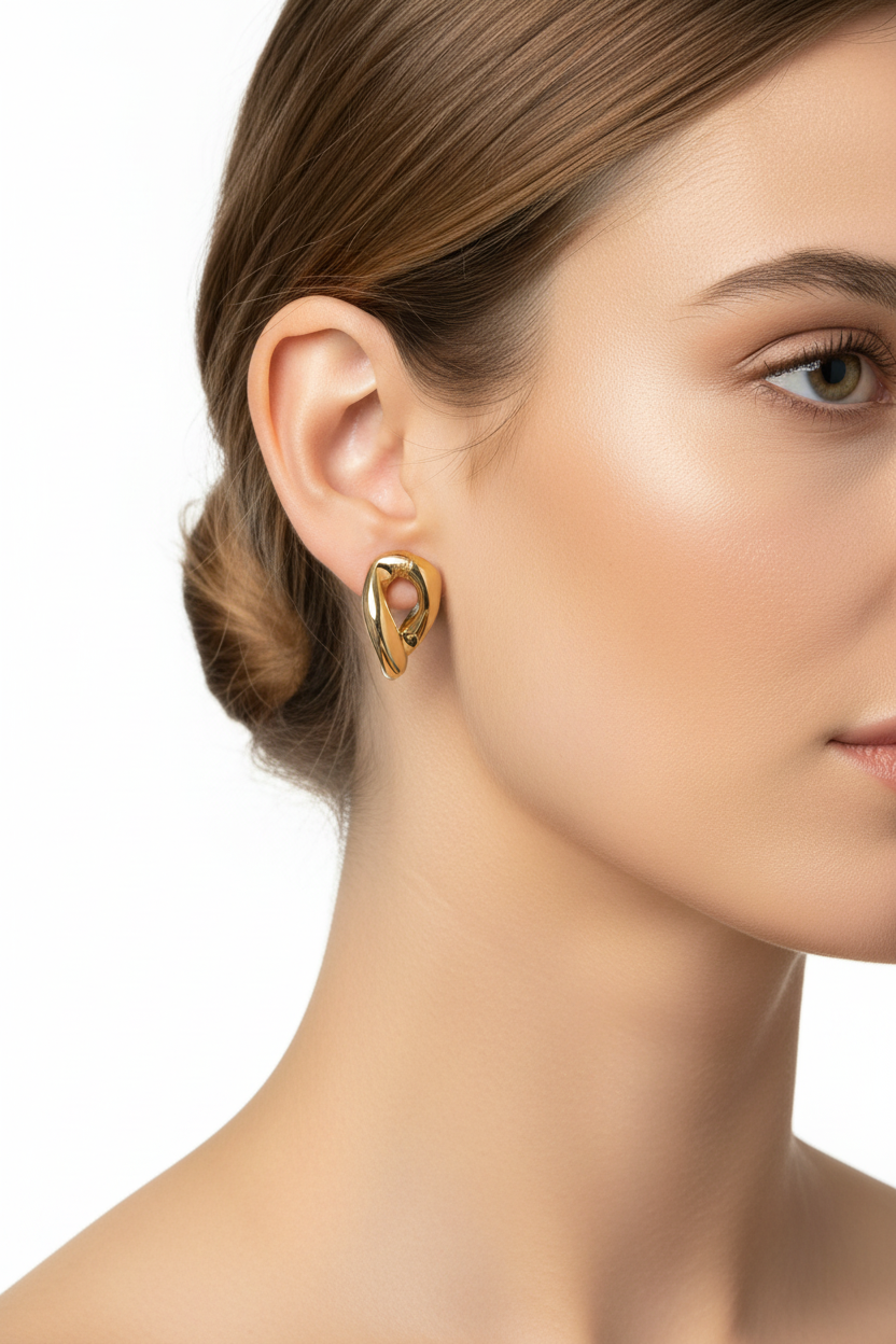 Gold sculptural stud earrings on model