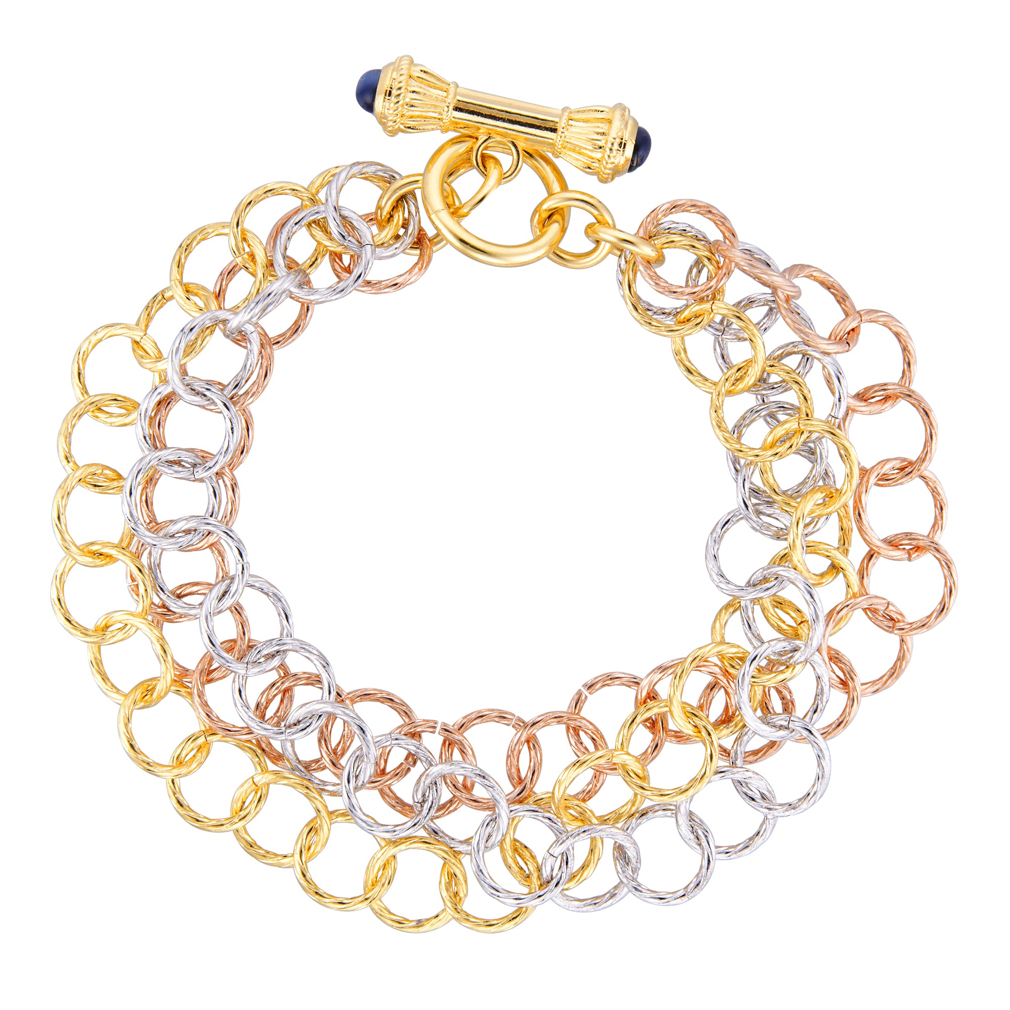 A multi-metal bracelet featuring interlocking chains in gold, silver, and rose gold hues. The bracelet has a layered design with alternating colored rings that create a visually striking effect. It is secured with a decorative toggle clasp that is accented with dark blue beads, adding a touch of elegance to the overall piece. The combination of colors and textures makes this bracelet a versatile accessory suitable for various occasions.