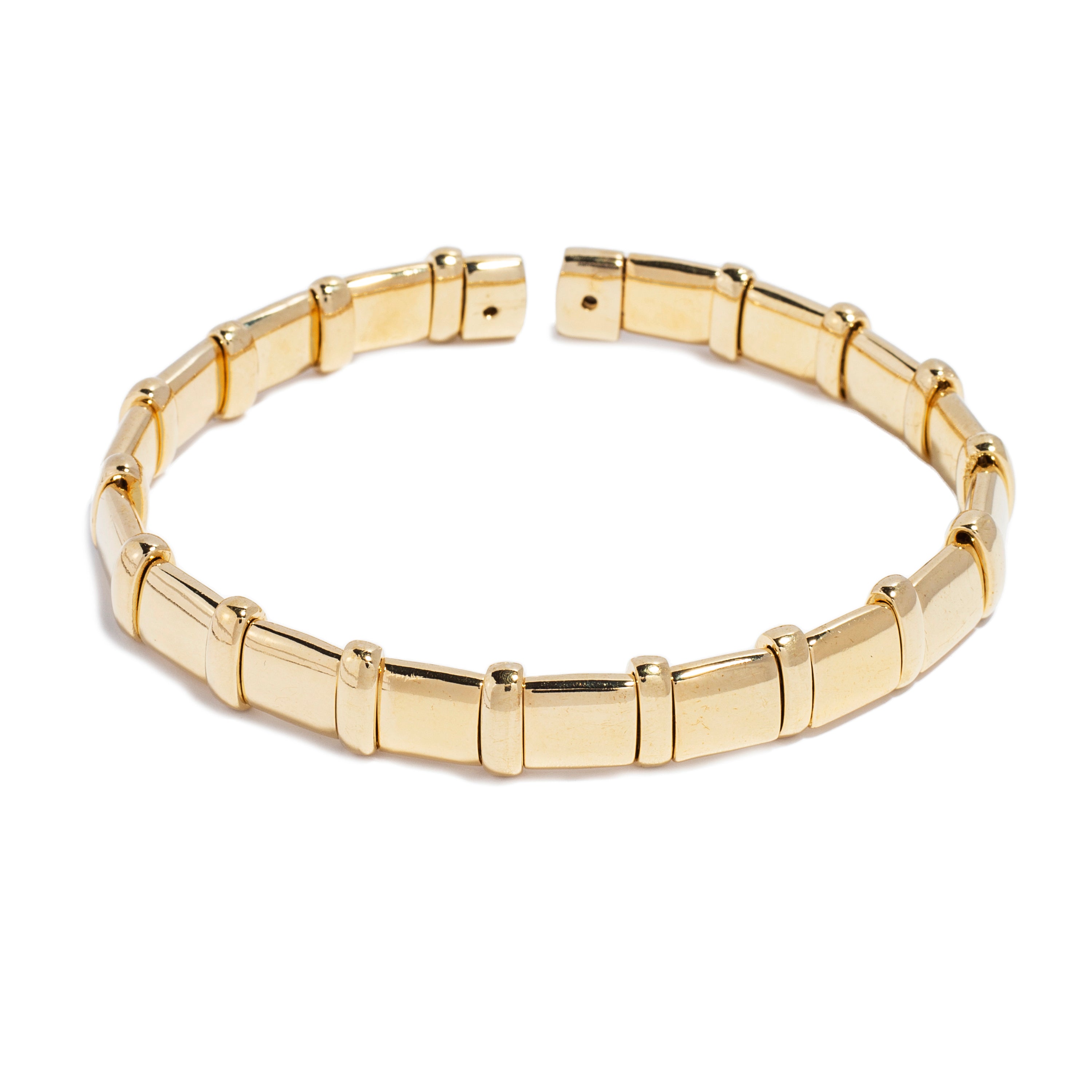 A stylish gold bracelet designed with a series of polished, rectangular and cylindrical links that alternate in shape. The bracelet features a flexible design that allows it to fit comfortably on the wrist. Its modern aesthetic and shiny finish make it an elegant accessory suitable for various occasions.