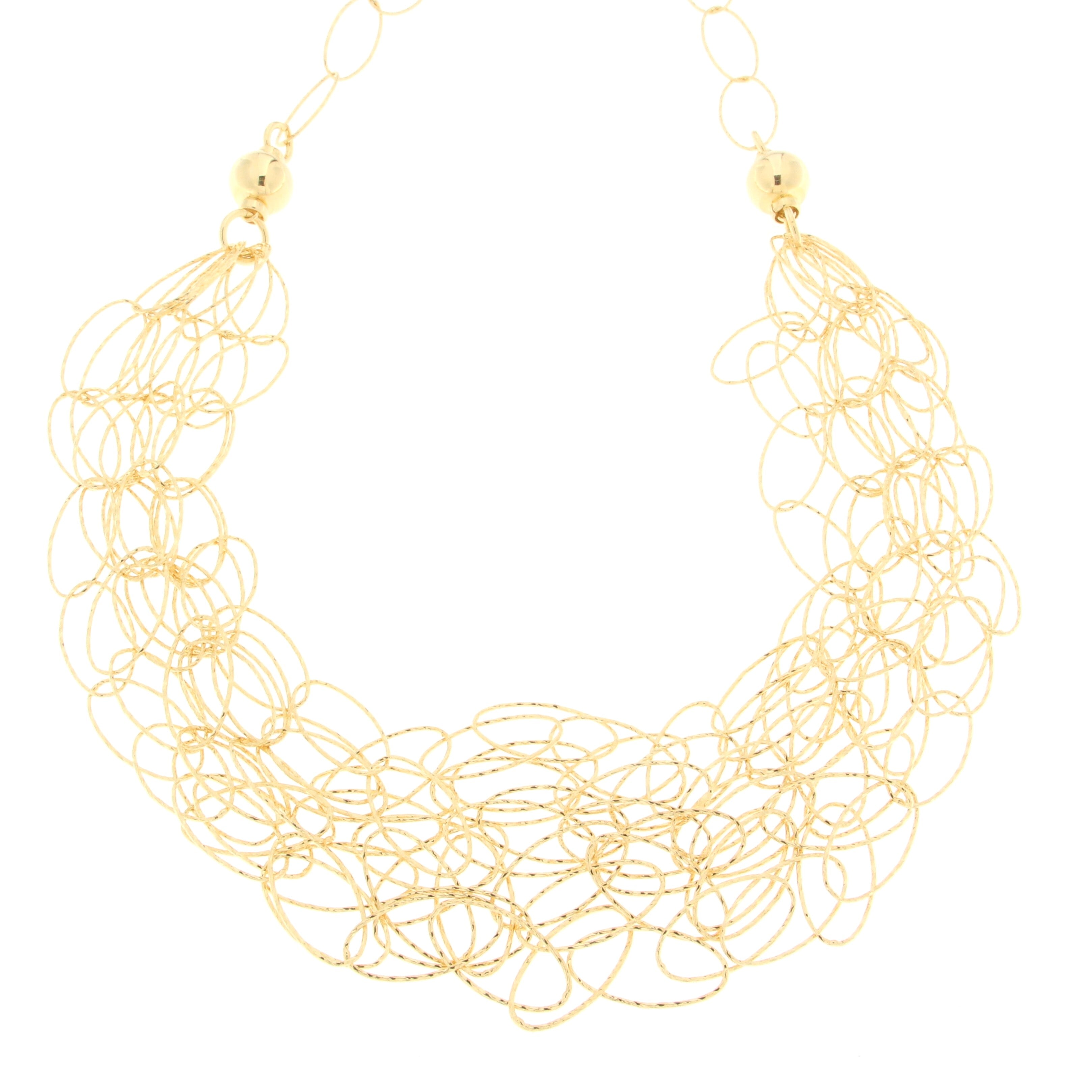 Artistic gold necklace with intertwined circular loops creating a lace-like effect, featuring round beads for added detail, showcasing a unique and elegant design.