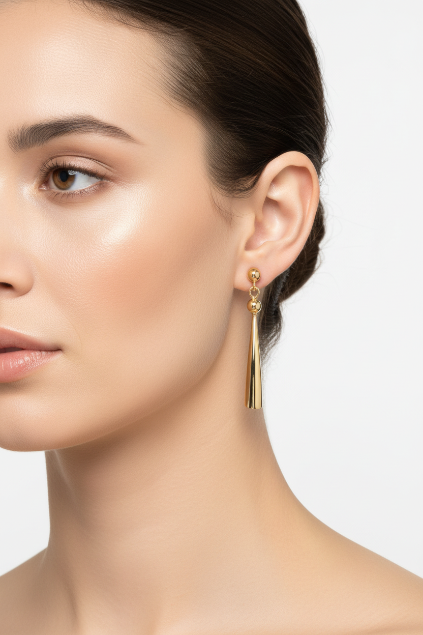 Gold tapered drop earrings on model