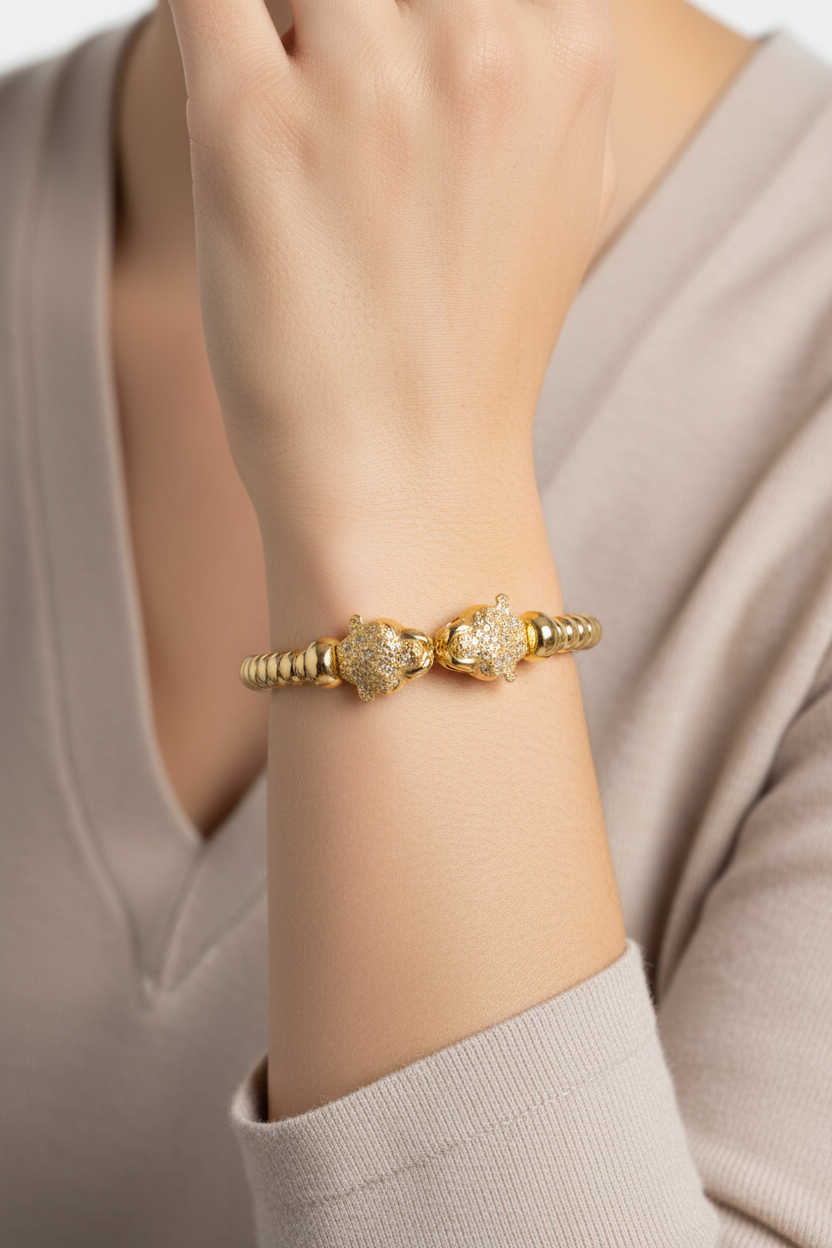 18K yellow-gold plated panther bangle bracelet worn on a model’s wrist