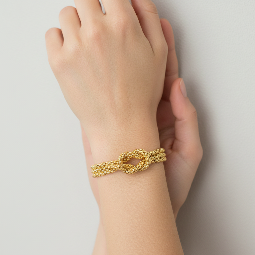 Multi-strand gold chain bracelet with knot detail on model's wrist